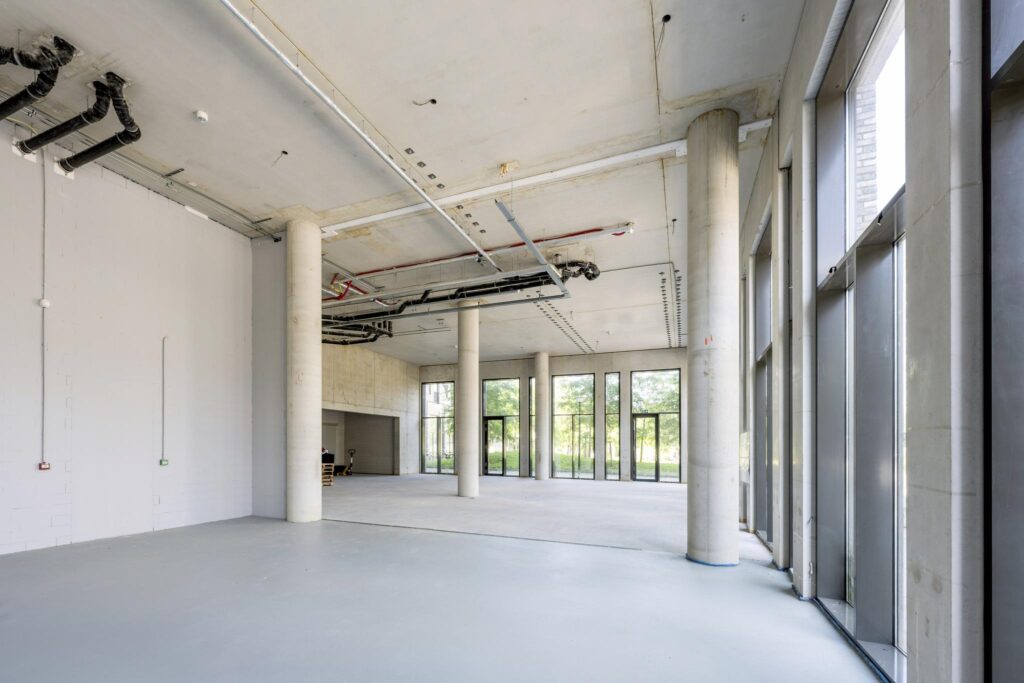 Empty commercial space with large windows and concrete columns at Elizabeth Cady Stantonplein.